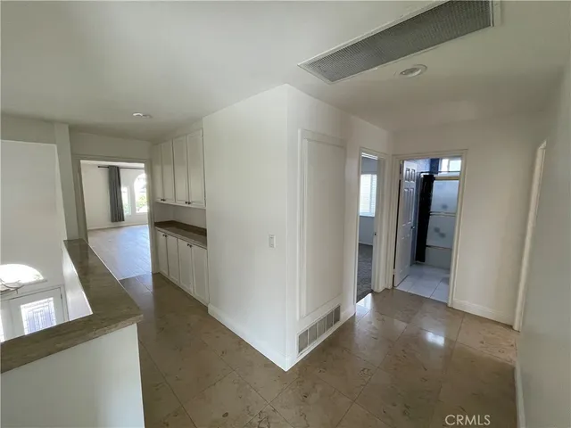 a view of a hallway with entryway and wooden floor
