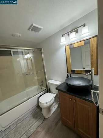 a kitchen with granite countertop stainless steel appliances a stove a sink and wooden cabinets