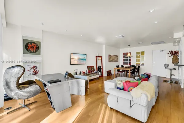 a living room with furniture and a wooden floor
