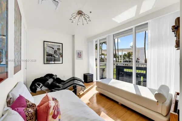 a bedroom with furniture and a large window