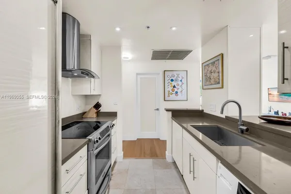 a kitchen with stainless steel appliances a sink a stove and cabinets
