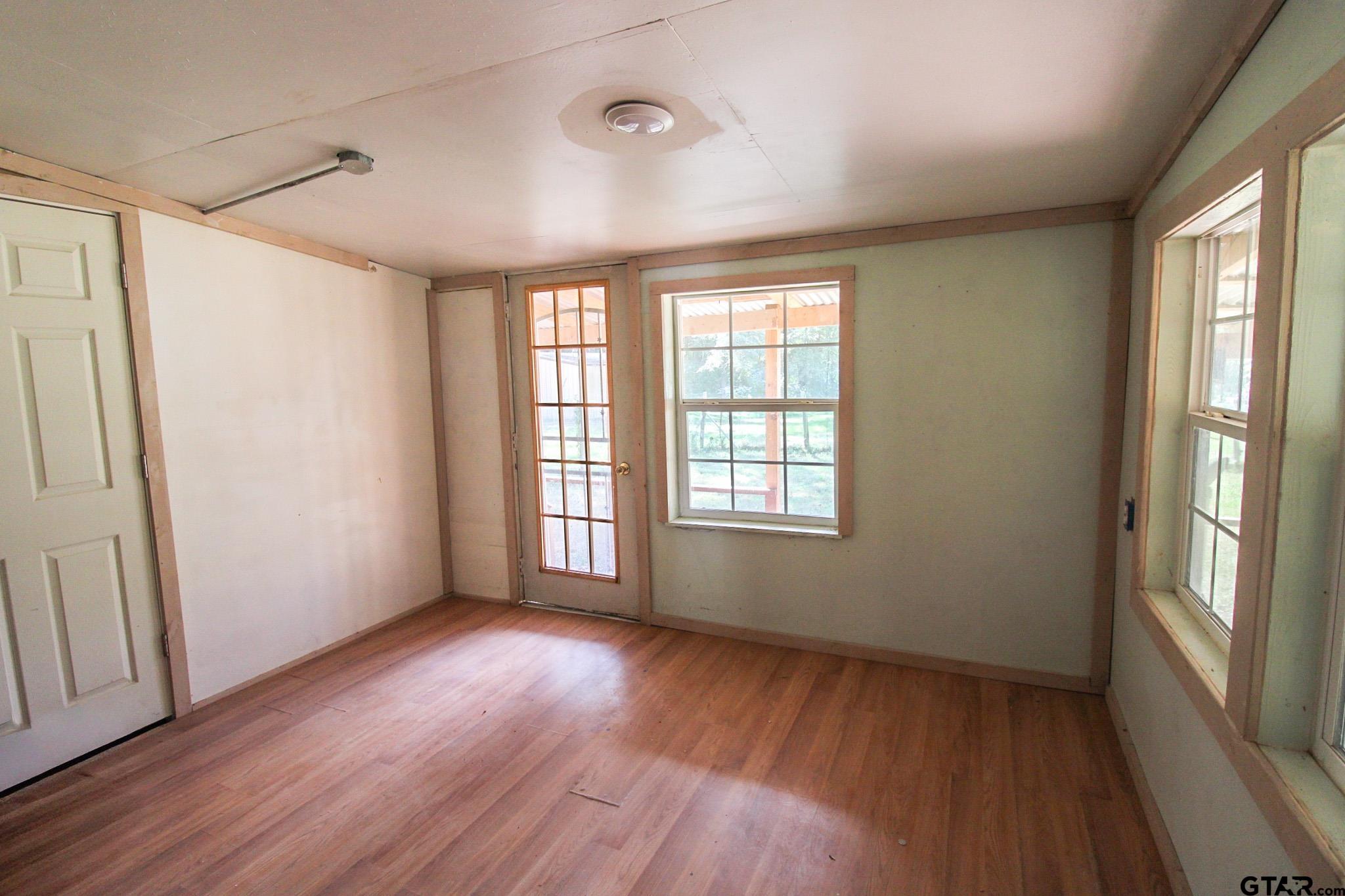 407 Pace Street Naples, TX 75568 - Photo 12 of 31 a view of an empty room with wooden floor and a window