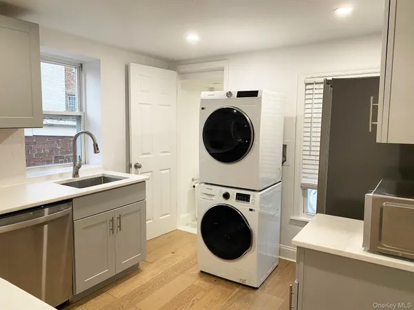a view of a kitchen with sink washer and dryer