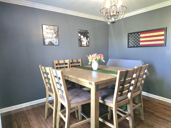a view of a dining room with furniture a chandelier and wooden floor