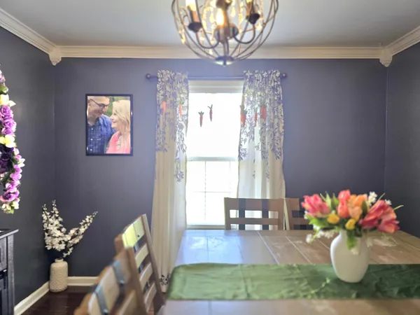 a living room with dining room and a chandelier