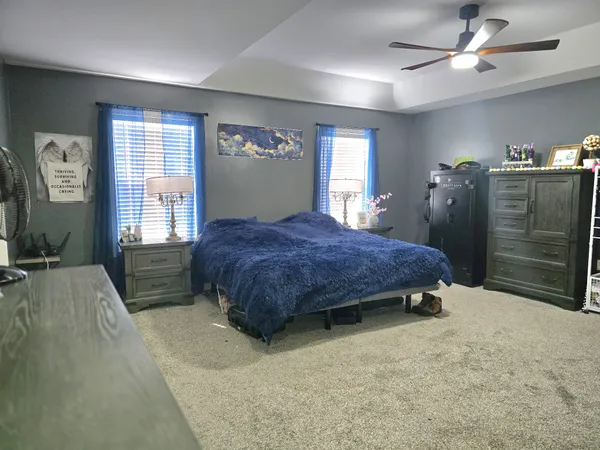 a spacious bedroom with a bed and a chandelier