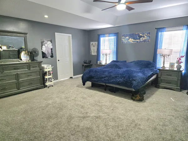 a spacious bedroom with a bed and a chandelier