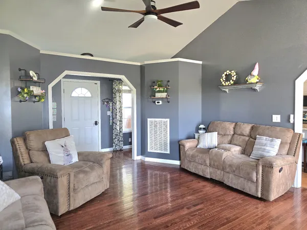 a living room with furniture and a wooden floor