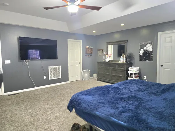 a bedroom with a bed dresser and a dining table