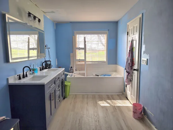 a bathroom with a sink a bathtub and a window