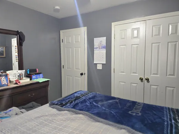 a bedroom with a bed dresser and a window