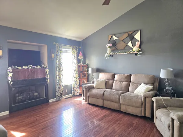 a living room with furniture and a wooden floor