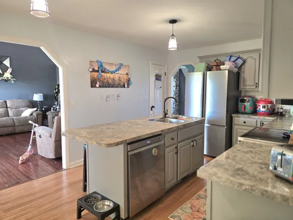 a kitchen with stainless steel appliances granite countertop a refrigerator and a sink
