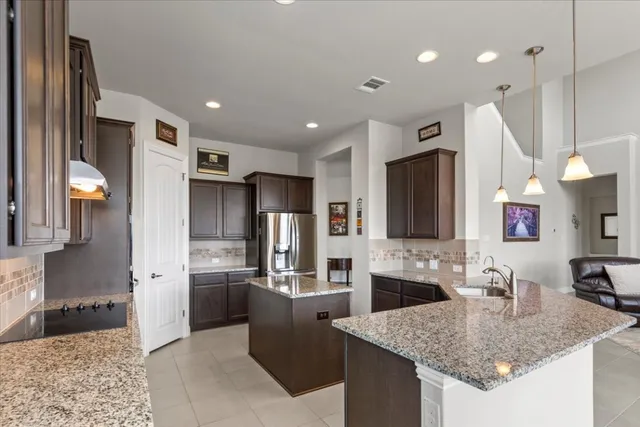 a kitchen with stainless steel appliances granite countertop a sink refrigerator and cabinets