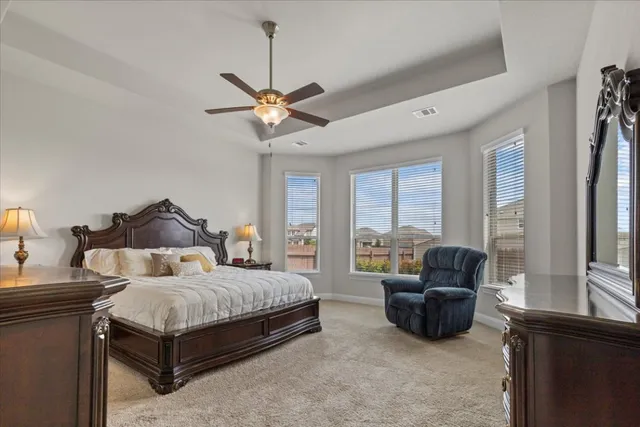 a bedroom with a bed couch and a large window