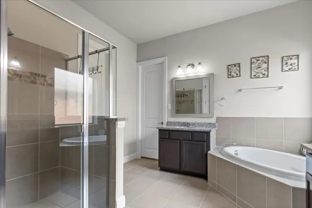 a bathroom with a tub sink shower and mirror