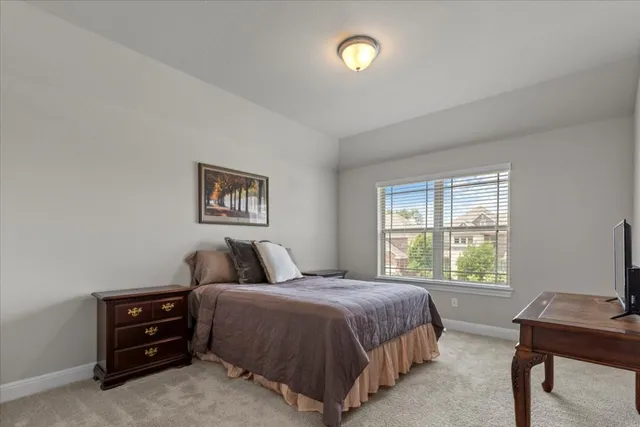 a bedroom with a bed painting on wall and windows