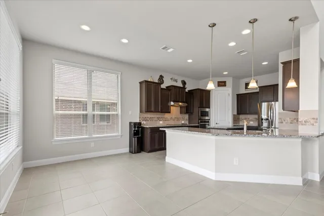 a large kitchen with a large counter top appliances and cabinets
