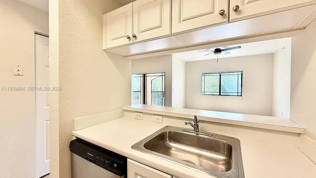a kitchen with a sink cabinets and a window