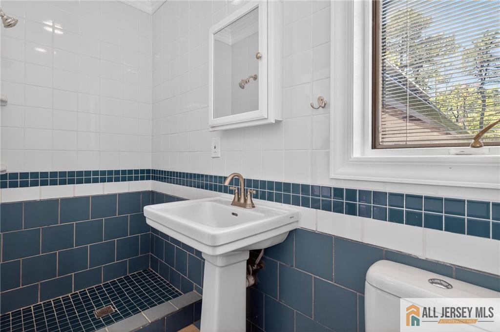381 Monmouth Road Freehold, NJ 07728 - Photo 48 of 63 a bathroom with a sink a toilet and a mirror
