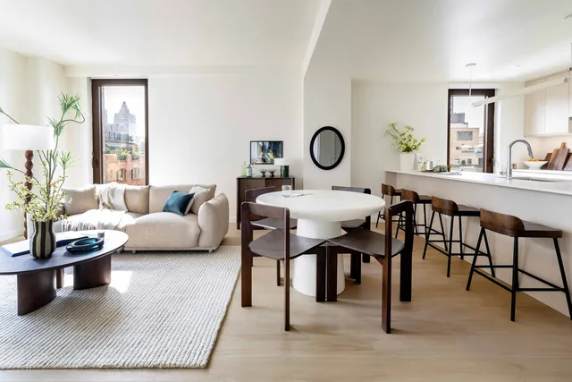 a living room with furniture a clock on wall and a window