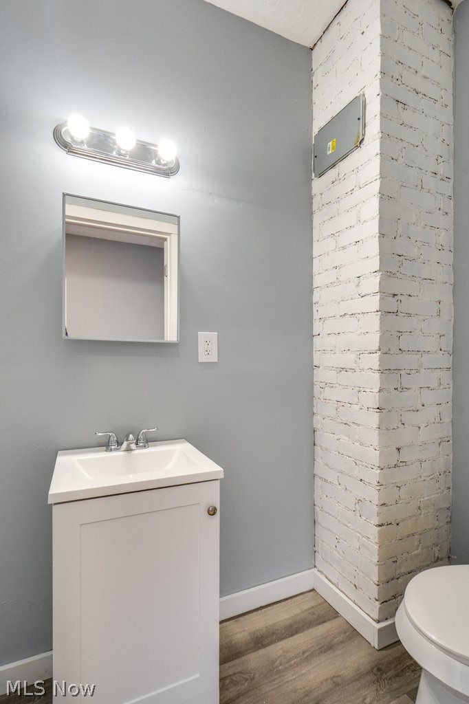 1607 9th Street Southwest Canton, OH 44706 - Photo 15 of 41 White painted brick column accenting a vanity with a white basin sink, chrome faucet, and mirrored medicine cabinet