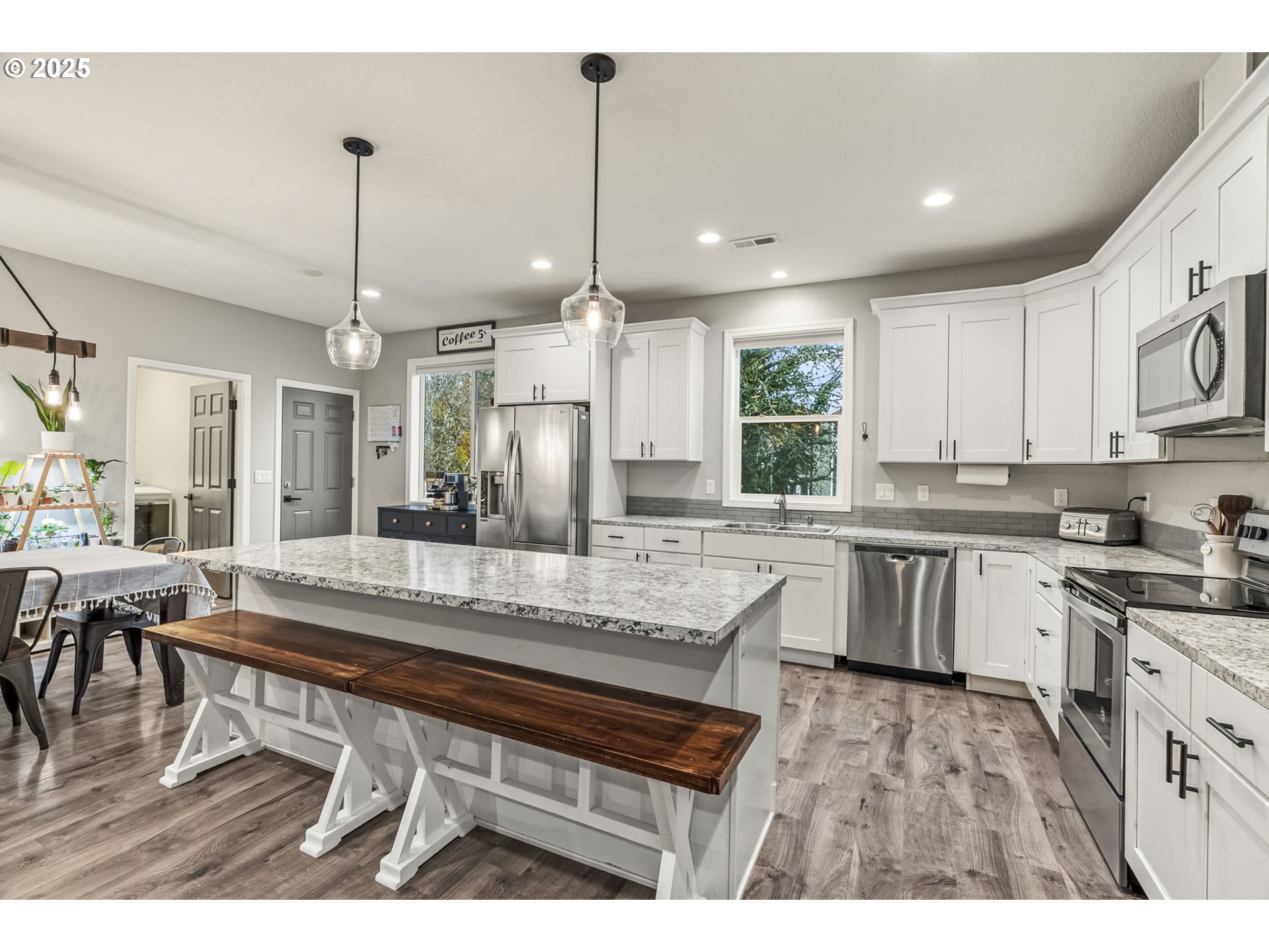 1783 Lewis River Road Woodland, WA 98674 - Photo 9 of 32 a kitchen with kitchen island granite countertop a table chairs a sink dishwasher window and cabinets