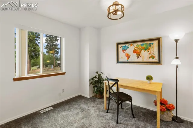 a view of a workspace with furniture and a window