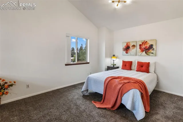 a bedroom with a bed and painting on the wall