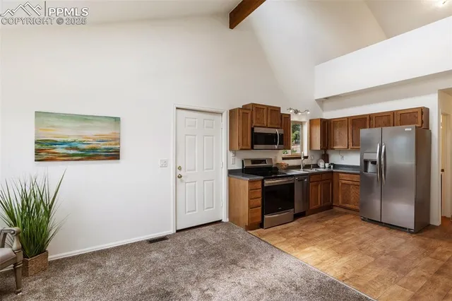 a kitchen with granite countertop a refrigerator and a stove top oven
