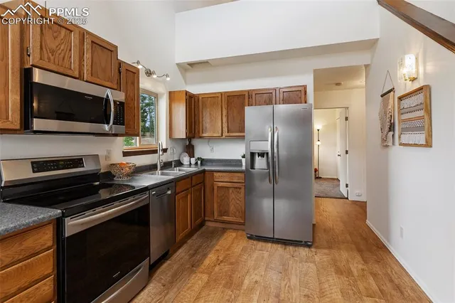 a kitchen with stainless steel appliances granite countertop a refrigerator microwave and stove top oven