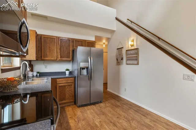 a kitchen with stainless steel appliances granite countertop a refrigerator a sink a stove and island