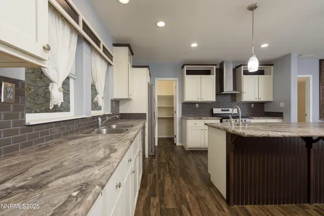 a kitchen with stainless steel appliances kitchen island granite countertop a stove a sink and a refrigerator