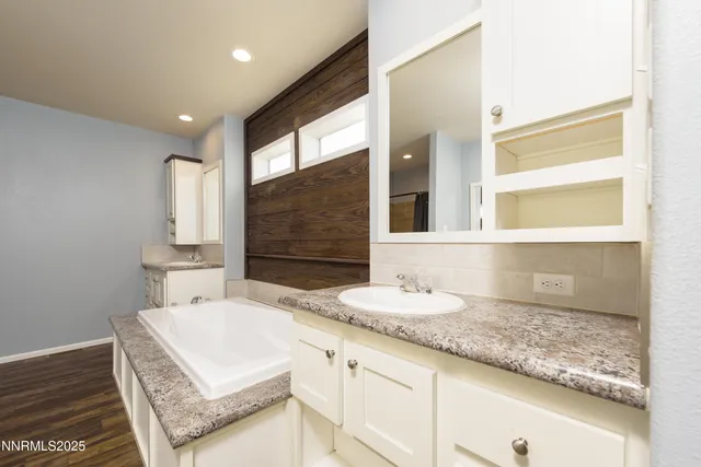 a spacious bathroom with a granite countertop sink and a mirror