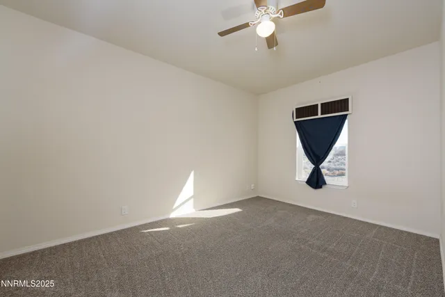 an empty room with a ceiling fan and a window