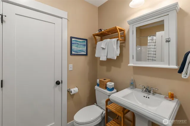 a bathroom with a sink mirror and toilet