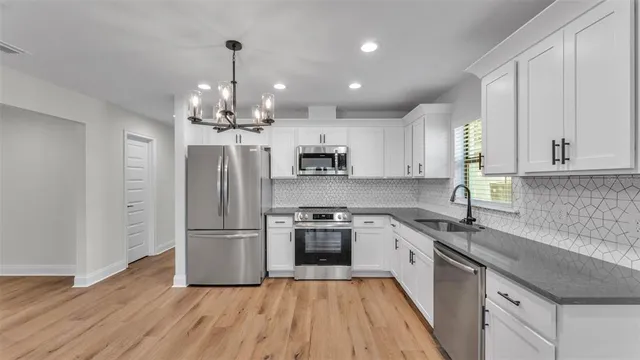 a kitchen with kitchen island granite countertop a sink stainless steel appliances and cabinets