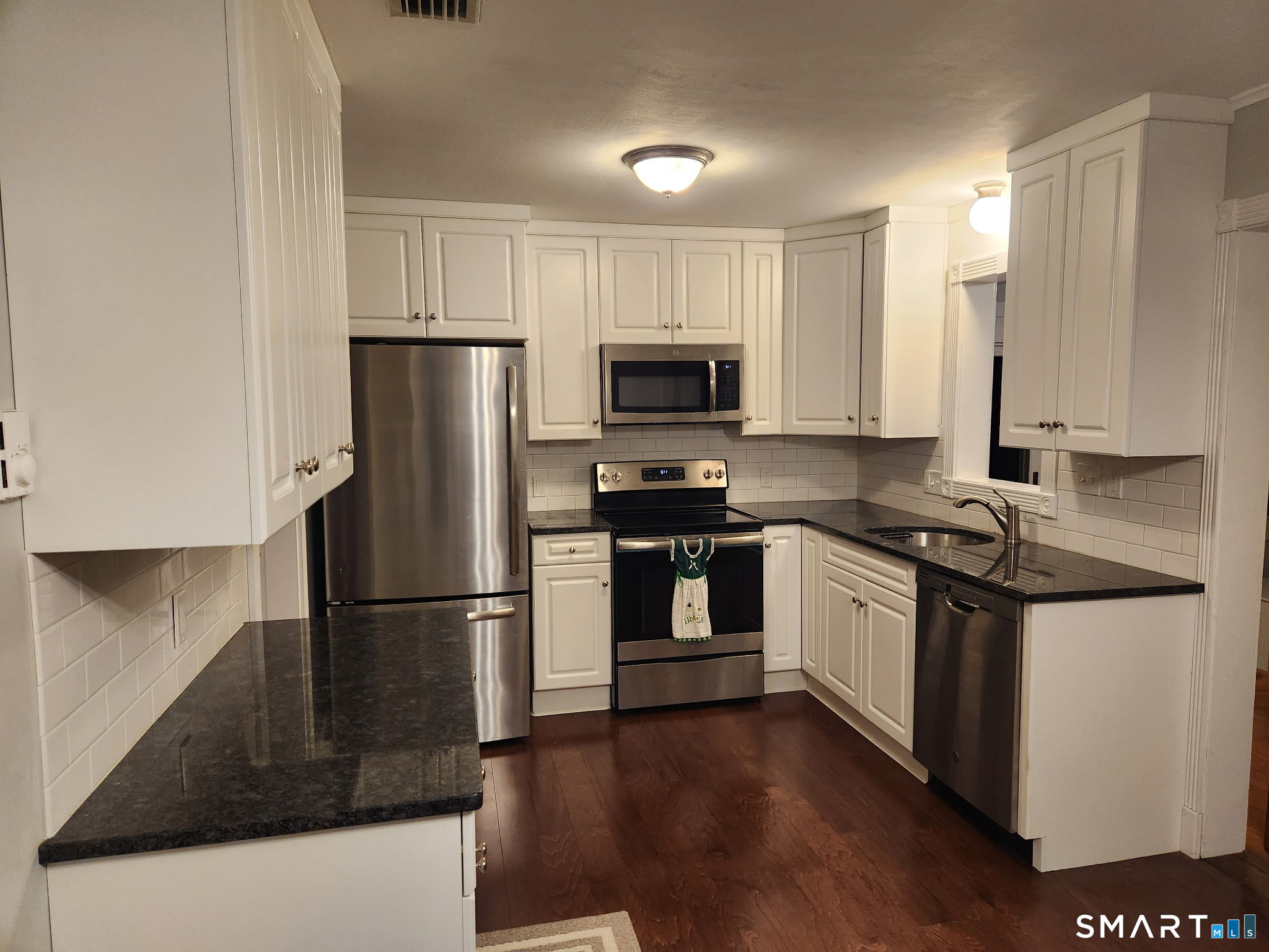 45 Fieldstream Drive Waterbury, CT 06704 - Photo 5 of 16 a kitchen with granite countertop a refrigerator stove and wooden cabinets