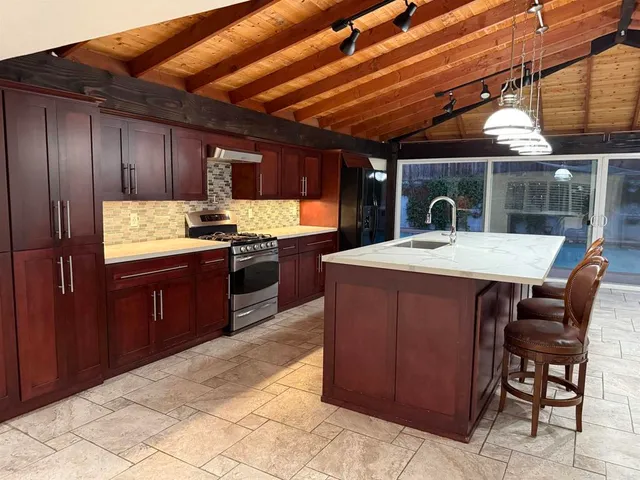 a kitchen with a stove sink and cabinets