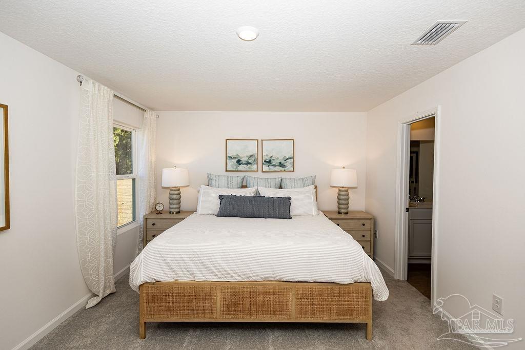 7761 Moonrise Way Milton, FL 32583 - Photo 9 of 19 a bedroom with a large bed and a chandelier