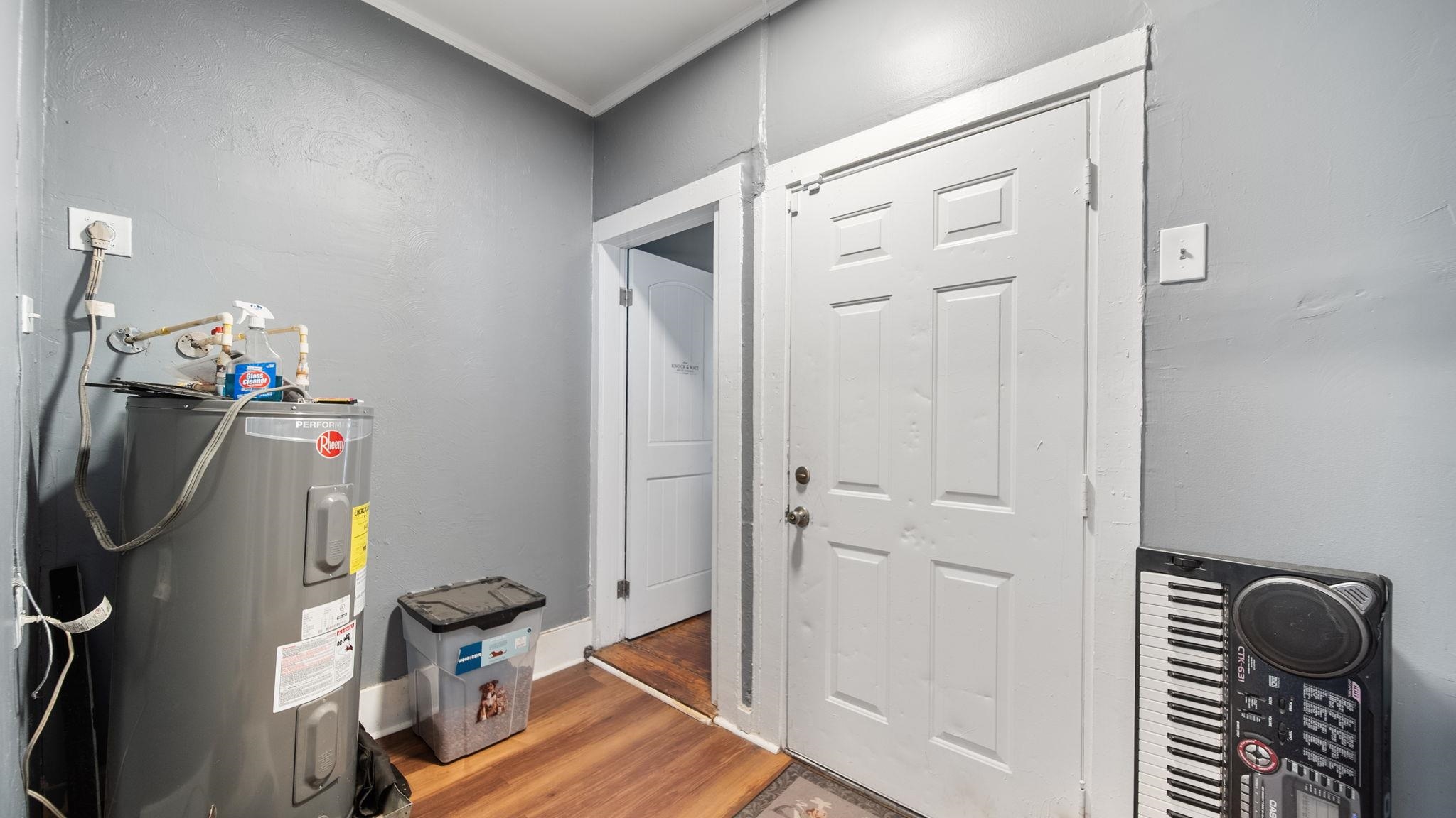 659 Decatur Street Memphis, TN 38107 - Photo 20 of 24 Interior utility area featuring a water heater, wood-finish flooring, and two paneled interior doors
