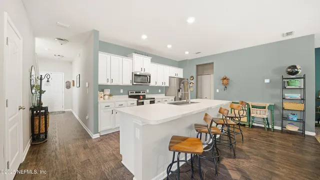 a kitchen with white cabinets and stainless steel appliances