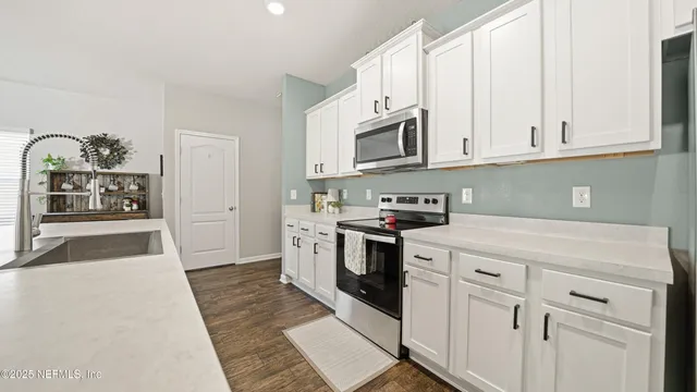 a kitchen with white cabinets and white appliances