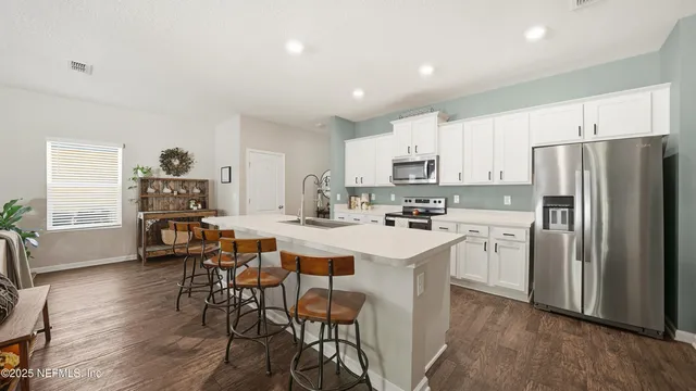 a kitchen with white cabinets and stainless steel appliances