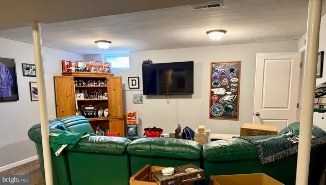 a living room with furniture a flat screen tv and a wall painting