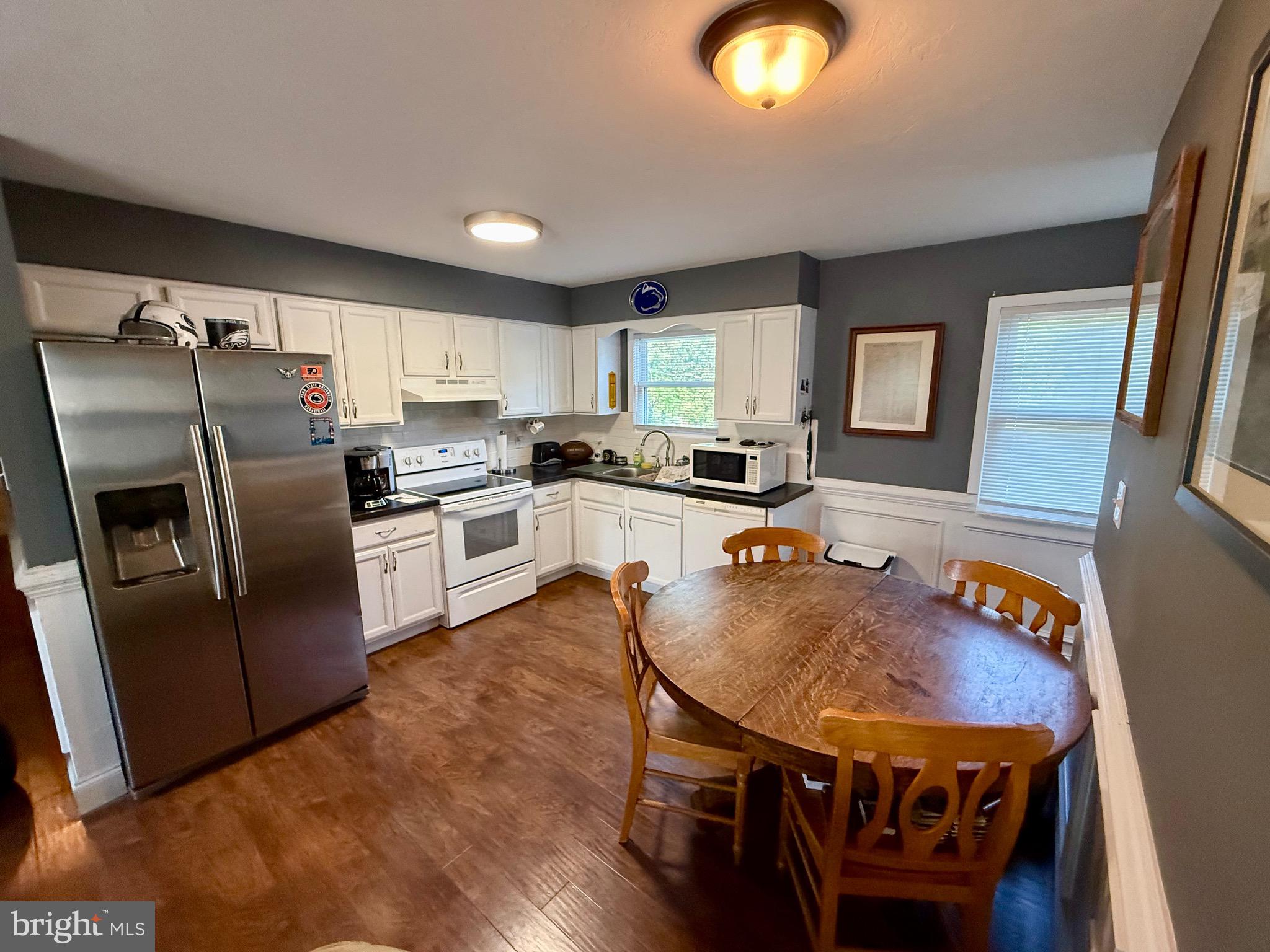 2856 West Canal Road Dover, PA 17315 - Photo 4 of 20 a kitchen with stainless steel appliances granite countertop a stove a refrigerator a sink a dining table and chairs