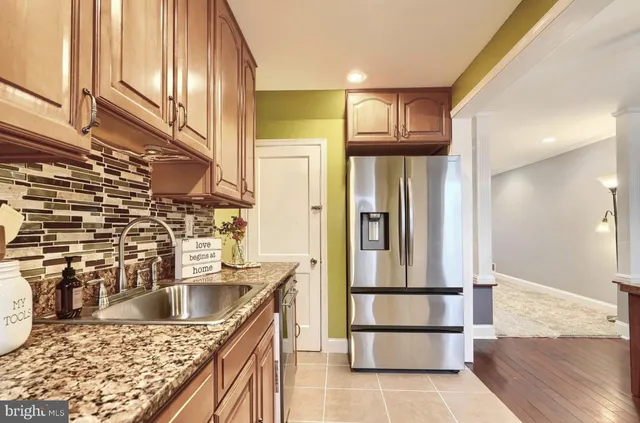 a kitchen with stainless steel appliances granite countertop a refrigerator and a sink