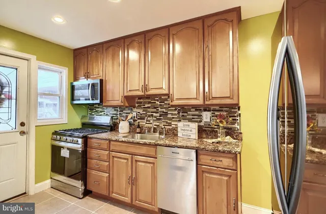 a kitchen with stainless steel appliances a stove a sink and a refrigerator