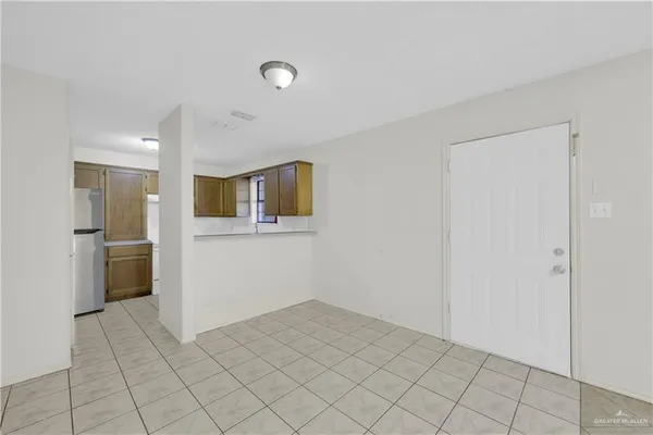 a view of a kitchen with refrigerator and white cabinets