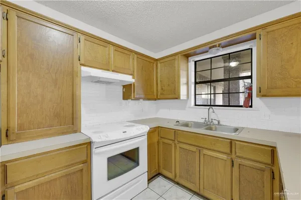a kitchen with a sink cabinets appliances and a window